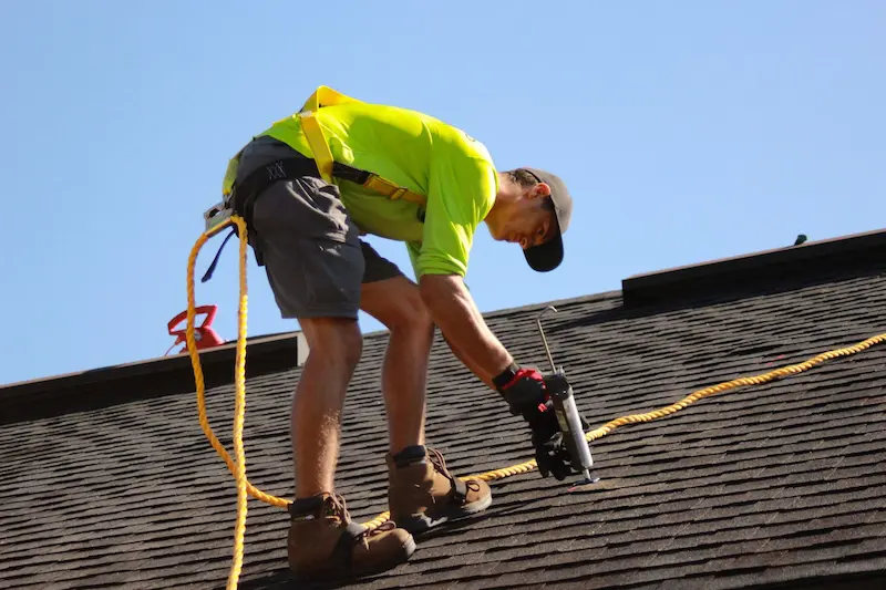 A man fixing a roof with a tool